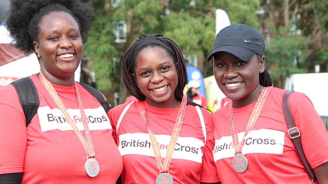 Three walkers with medals after finishing Walk for Humanity charity walk in London.