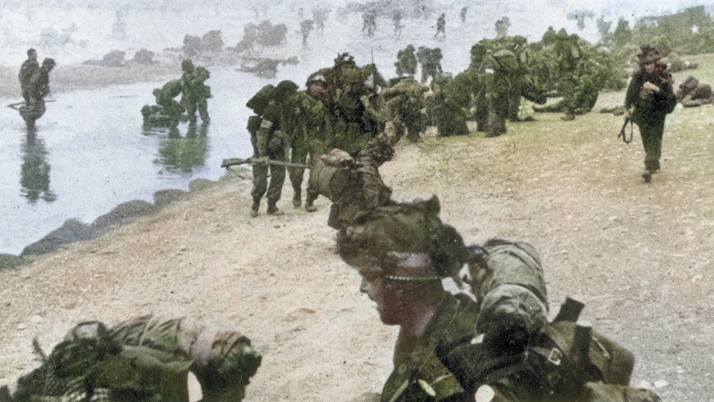 Many injured troops on a beach, with the sea and injured soldiers in the background