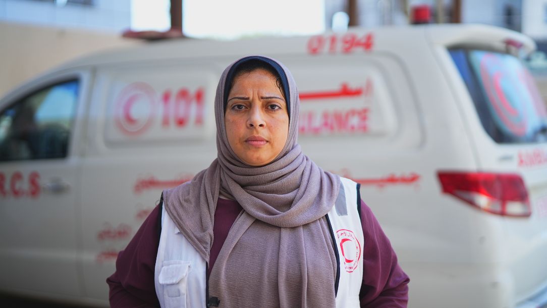 Tahreer from the Palestine Red Crescent Society has responded throughout the Gaza crisis and stands in front of an ambulance.