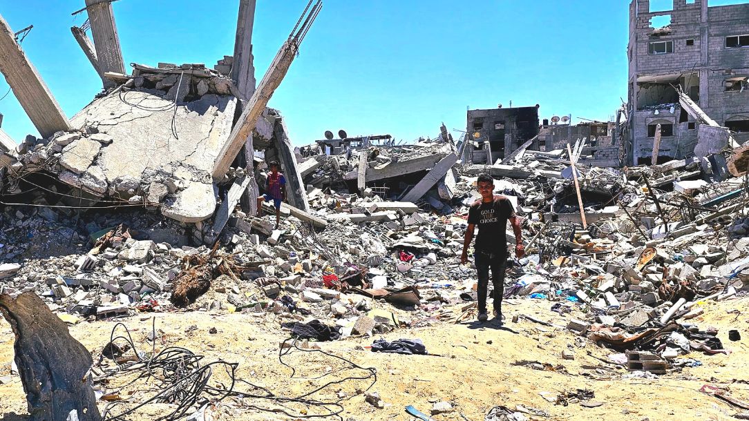 A man stands among destroyed buildings after the conflict in Gaza.